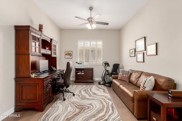 office area with a ceiling fan, wood finished floors, and baseboards