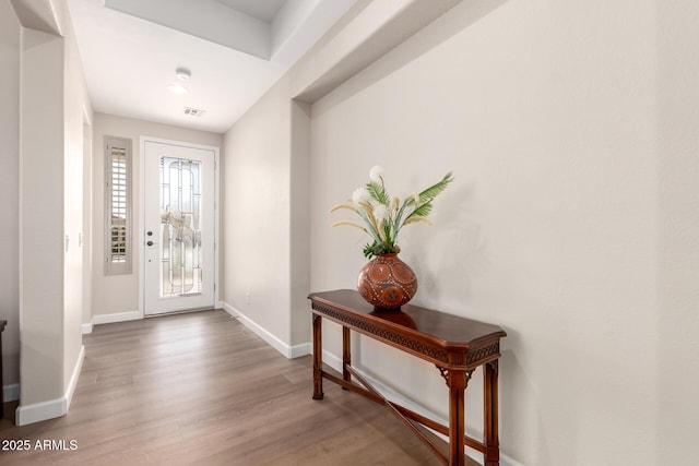entryway with visible vents, baseboards, and wood finished floors