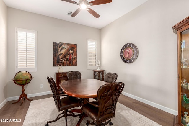 dining area featuring a ceiling fan, wood finished floors, and baseboards