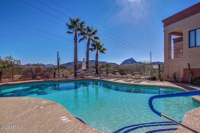 pool with a mountain view, fence, and a patio