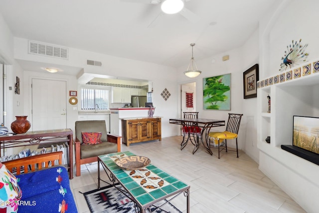 living area with visible vents and a ceiling fan