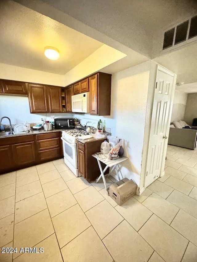 3840 N 43rd Ave Unit 29, Phoenix, AZ 85031 - kitchen featuring sink, light tile patterned floors, and white appliances