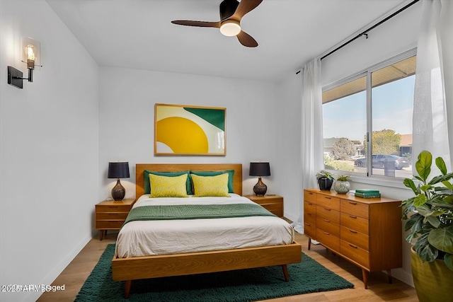 bedroom with baseboards, a ceiling fan, and wood finished floors