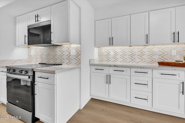 kitchen featuring stainless steel electric range oven, light stone counters, decorative backsplash, white cabinetry, and light wood-type flooring