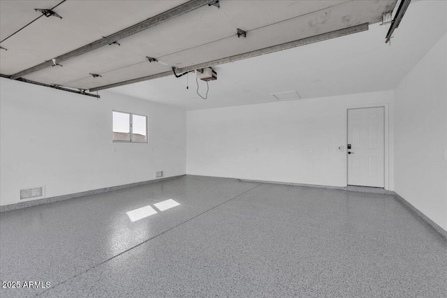 garage featuring visible vents, a garage door opener, and baseboards