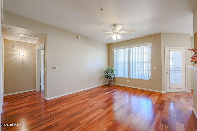 empty room with ceiling fan, wood-type flooring, and a textured ceiling