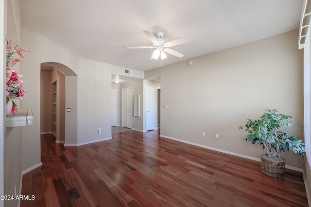 14950 W Mountain View Blvd Unit 1310, Surprise, AZ 85374 - empty room featuring arched walkways, a ceiling fan, wood finished floors, and baseboards