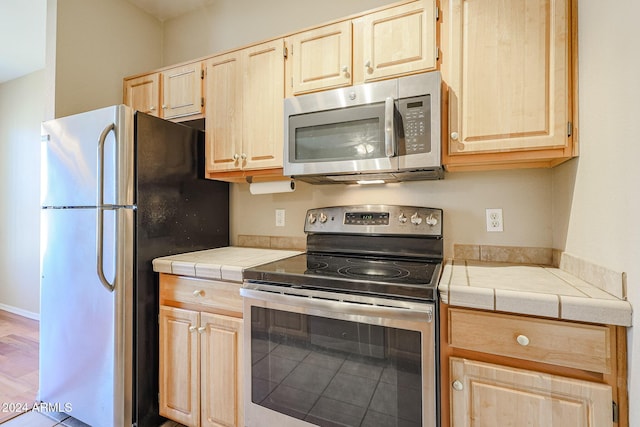 14950 W Mountain View Blvd Unit 1310, Surprise, AZ 85374 - kitchen featuring appliances with stainless steel finishes, light brown cabinetry, and tile countertops
