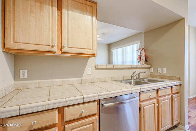 kitchen with dishwasher, sink, tile countertops, light brown cabinetry, and hardwood / wood-style flooring