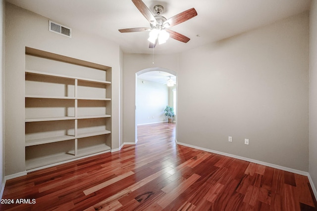 14950 W Mountain View Blvd Unit 1310, Surprise, AZ 85374 - spare room featuring a ceiling fan, arched walkways, built in shelves, wood finished floors, and baseboards