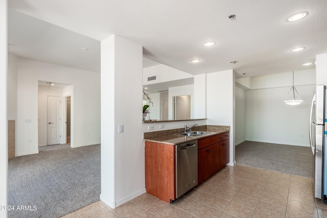 kitchen with appliances with stainless steel finishes, light carpet, sink, and hanging light fixtures