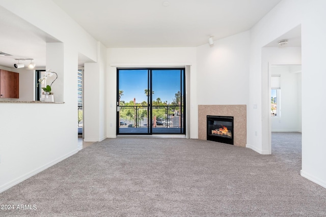 unfurnished living room with a tile fireplace and carpet