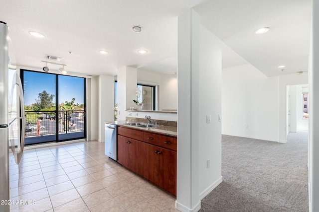 kitchen featuring light colored carpet, sink, and appliances with stainless steel finishes