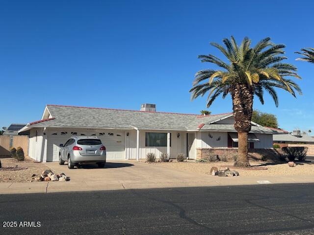 ranch-style home featuring a garage and concrete driveway