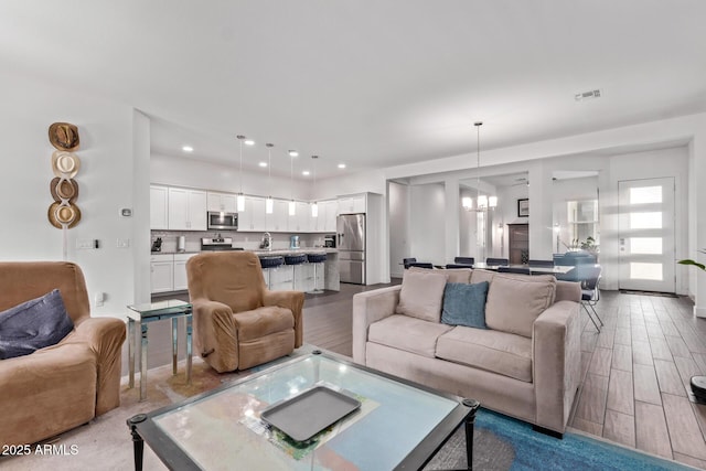 939 E Paseo Way, Phoenix, AZ 85042 - living area with a chandelier, wood finished floors, and recessed lighting