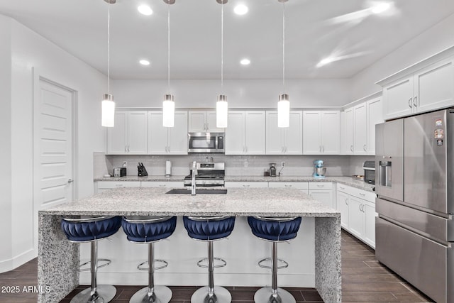 939 E Paseo Way, Phoenix, AZ 85042 - kitchen with stainless steel appliances, a sink, dark wood-type flooring, backsplash, and white cabinets