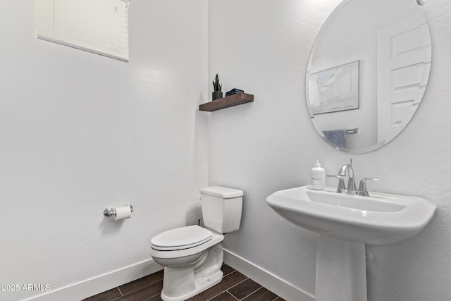 939 E Paseo Way, Phoenix, AZ 85042 - bathroom featuring wood finished floors, toilet, baseboards, and a sink