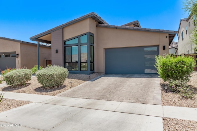 939 E Paseo Way, Phoenix, AZ 85042 - view of front of home featuring driveway, stucco siding, an attached garage, and a tiled roof
