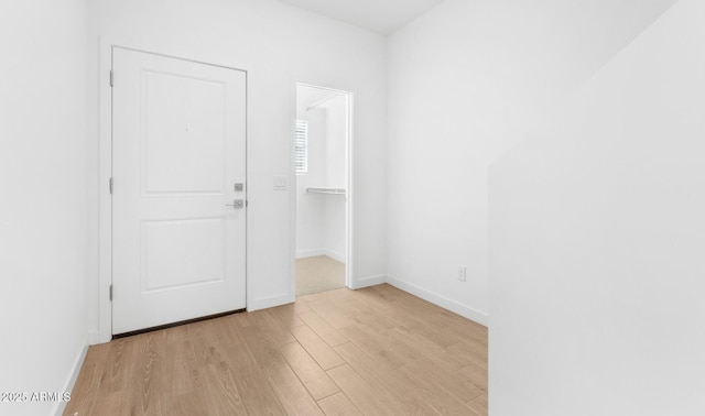 spare room featuring light wood-style floors and baseboards