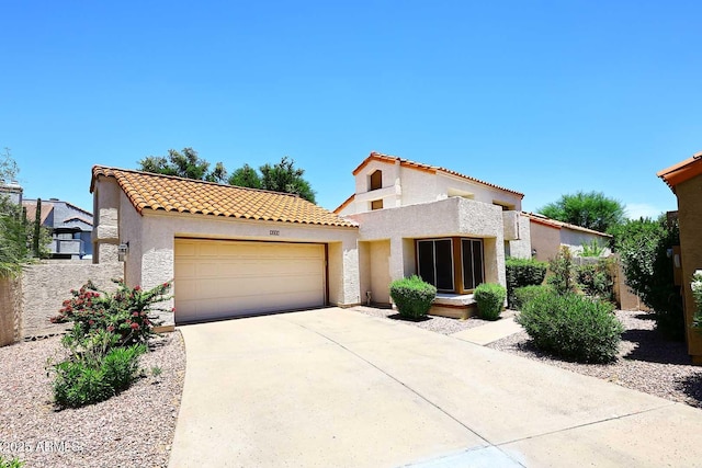 9235 N 101st St, Scottsdale, AZ 85258 - mediterranean / spanish-style house with stucco siding, an attached garage, a tile roof, and concrete driveway