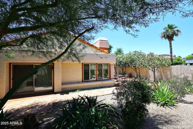 9235 N 101st St, Scottsdale, AZ 85258 - back of property featuring stucco siding, a chimney, and a patio