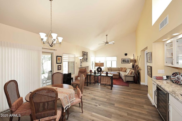 9235 N 101st St, Scottsdale, AZ 85258 - dining room with high vaulted ceiling, wood finished floors, a ceiling fan, a chandelier, and beverage cooler