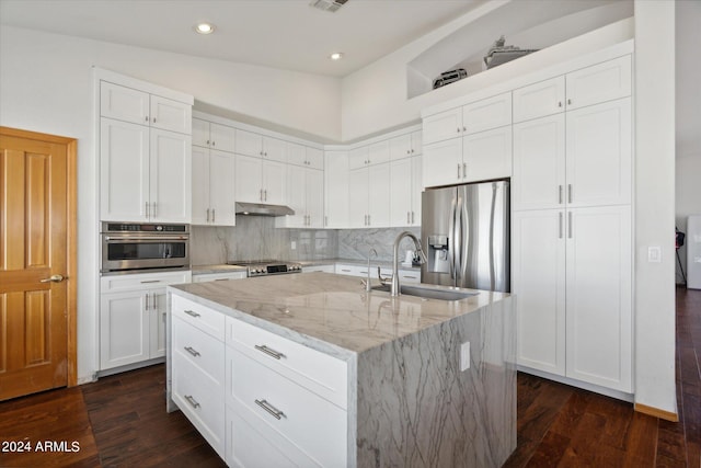 kitchen featuring sink, dark wood-type flooring, stainless steel appliances, an island with sink, and vaulted ceiling