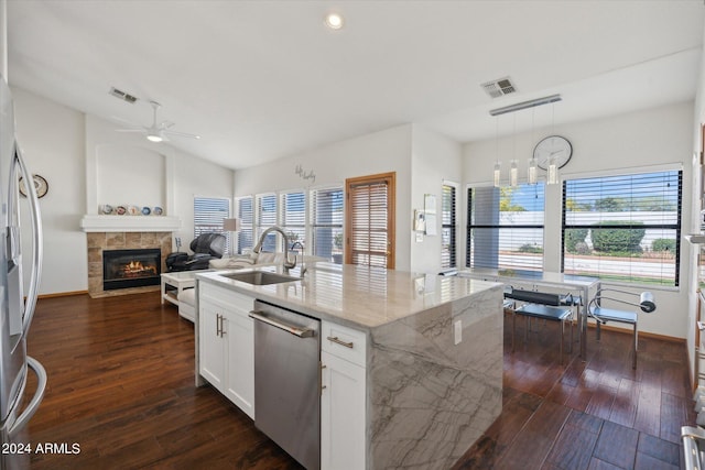 kitchen featuring white cabinetry, sink, hanging light fixtures, light stone counters, and appliances with stainless steel finishes