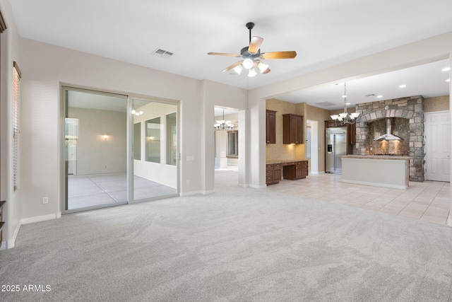 unfurnished living room featuring ceiling fan with notable chandelier and light carpet