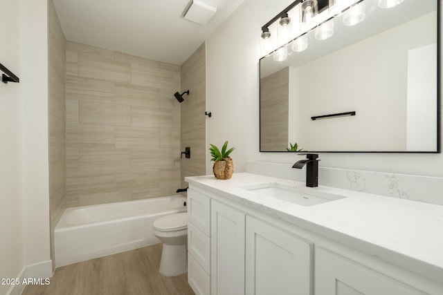 full bath featuring shower / bath combination, toilet, wood finished floors, and vanity