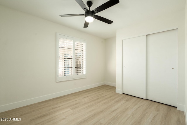 unfurnished bedroom featuring a ceiling fan, wood finished floors, a closet, and baseboards