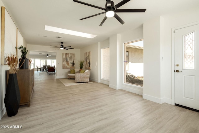 entrance foyer with light wood finished floors, visible vents, a skylight, and baseboards