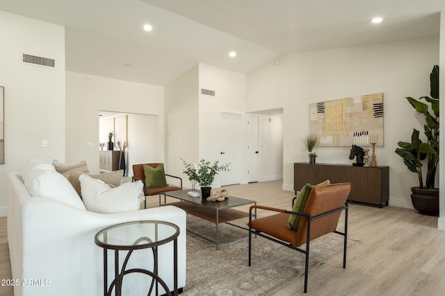 living area featuring light wood-type flooring, visible vents, high vaulted ceiling, and recessed lighting