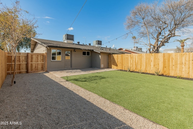 back of house featuring a lawn, a patio, and central air condition unit