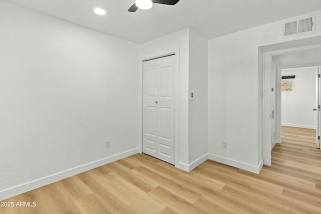 unfurnished bedroom with ceiling fan, light hardwood / wood-style floors, and a closet