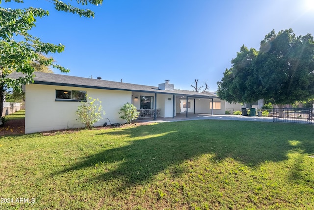 rear view of house with a patio area and a yard