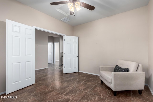 living area featuring baseboards, visible vents, and a ceiling fan