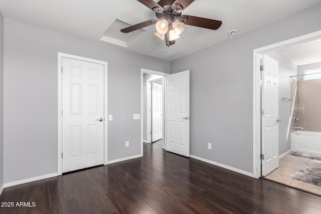unfurnished bedroom featuring wood finished floors, ensuite bathroom, baseboards, visible vents, and ceiling fan