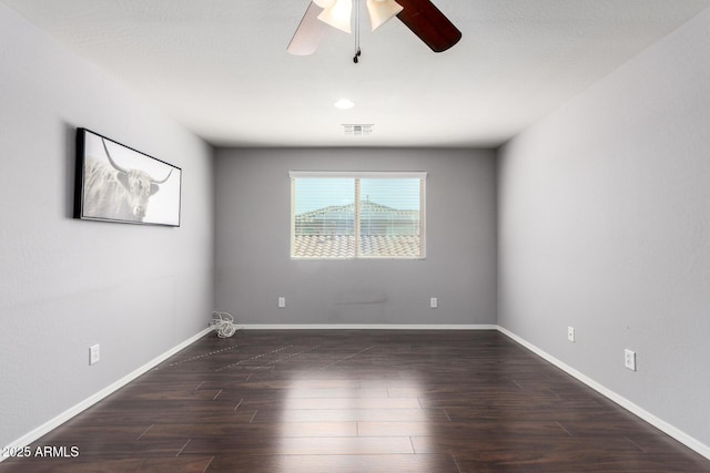 empty room with baseboards, visible vents, wood finished floors, and a ceiling fan