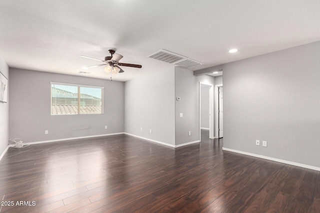 spare room featuring dark wood-style floors, visible vents, baseboards, and a ceiling fan