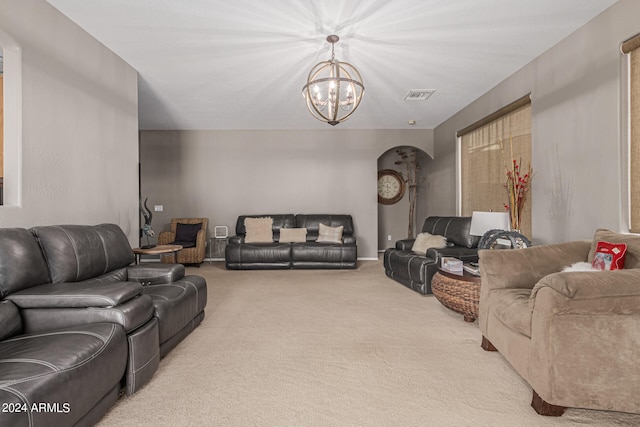 carpeted living room featuring an inviting chandelier