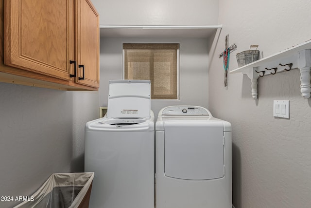 laundry room featuring cabinets and washer and dryer