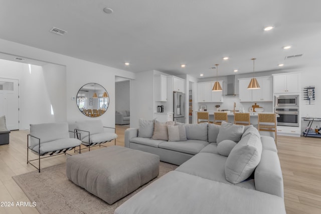 living room with sink and light wood-type flooring