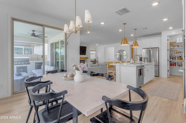 dining area with sink, light hardwood / wood-style flooring, and ceiling fan