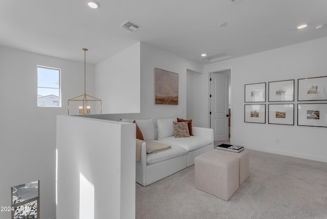 living room with an inviting chandelier and light carpet