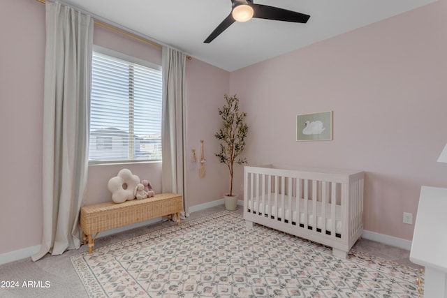 bedroom featuring ceiling fan and a crib