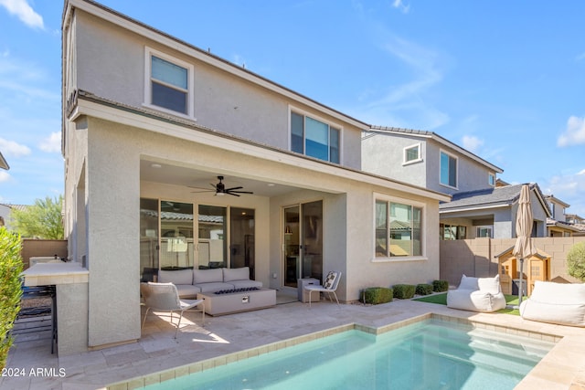 back of property featuring ceiling fan, an outdoor living space, a fenced in pool, and a patio