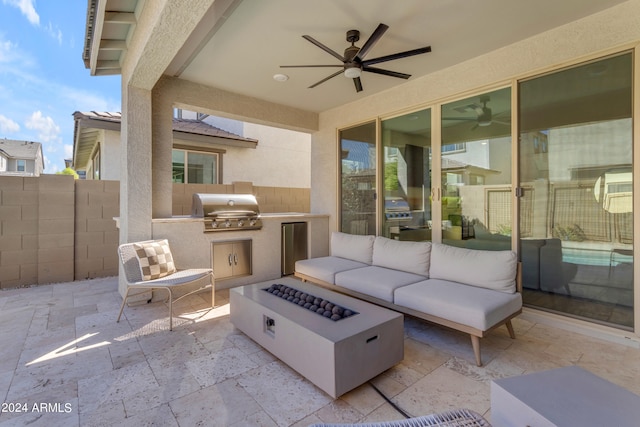 view of patio / terrace with exterior kitchen, a grill, ceiling fan, and an outdoor fire pit