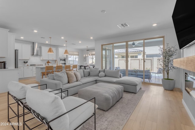 living room with sink, a fireplace, and light hardwood / wood-style floors