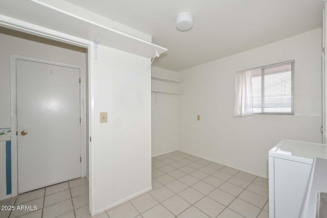 washroom with washer / clothes dryer, light tile patterned flooring, and laundry area